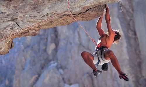 homme qui grimpe un rocher avec ses bras